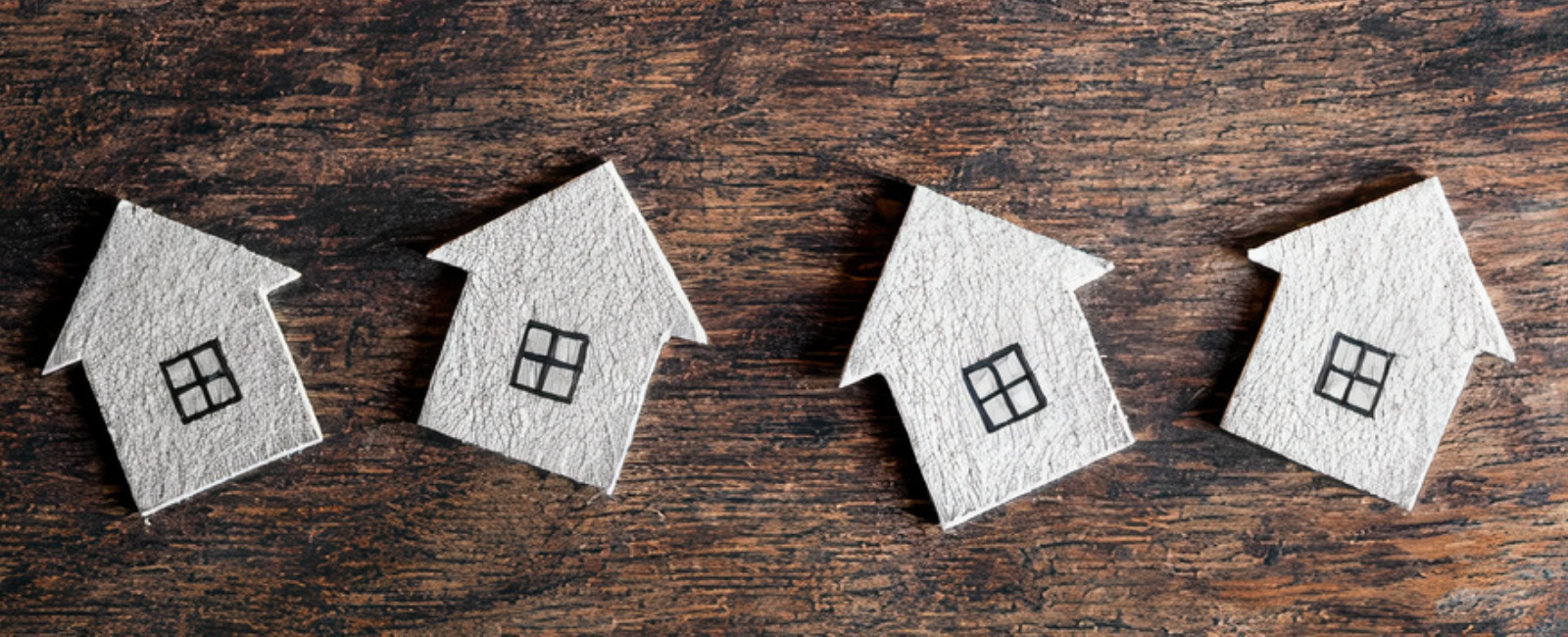 4 small houses on a wooden background